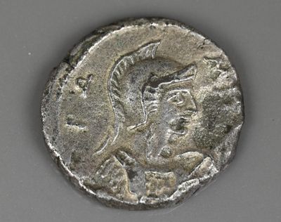 un gros plan d'une pièce de monnaie sur laquelle figure une tête romaine