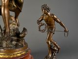 a bronze statue of a woman holding a bow and a man with a bow