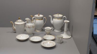 une table sur laquelle sont disposés de nombreux objets blancs et dorés