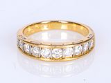 a close up of a gold and diamond ring on a white surface