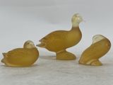 three ducks that are sitting next to each other on a table