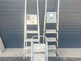 two ladders and a chair in front of a building