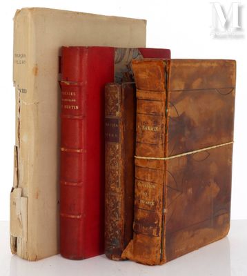 several old books are stacked on top of each other on a white surface