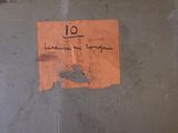 a piece of paper that has been written on the side of a wall