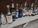 bottles of alcohol are lined up on a shelf in front of a window