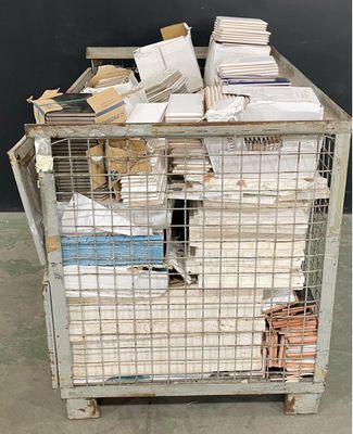a metal cage filled with lots of papers on the floor