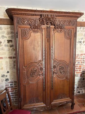 a large wooden armoire in the corner of a room