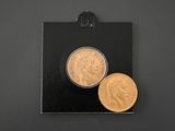 a close up of two gold coins on a black surface