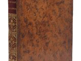 un vieux livre à la couverture brune posé sur une surface blanche