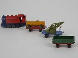 several toy trains are lined up on a white surface