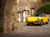 a yellow car parked in front of a stone building