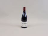 une bouteille de vin posée sur une table blanche