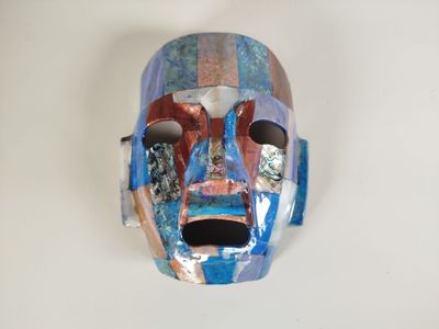 un masque posé sur une surface blanche, avec un fond blanc