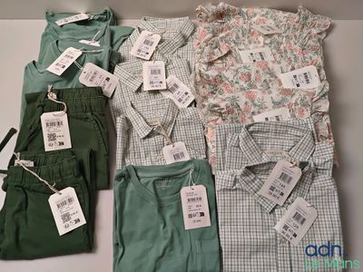 beaucoup de chemises et de pantalons posés sur la table