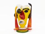 sculpture en verre aux couleurs vives représentant un homme avec des skis sur la tête