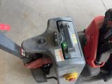 a red and black lawn mower with a red handle