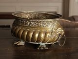 a metal bowl sitting on a wooden table in a room