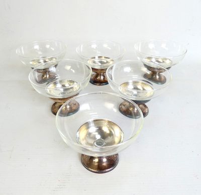 six bols en verre transparent à bord doré, posés sur un socle en bois