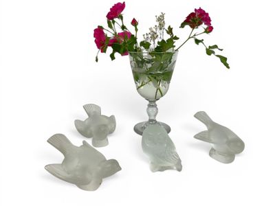 a glass vase with flowers in it and birds in the vase