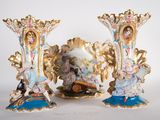 three vases with figurines on them sitting on a table