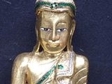 a gold statue of a person sitting on a black surface