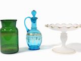 trois vases en verre de couleurs différentes posés sur une surface blanche