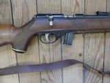 a rifle that is laying on the floor next to a gun