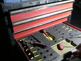 a man that is holding a tool box with tools in it