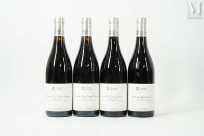 quatre bouteilles de vin sont alignées sur une surface blanche