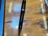 un ordinateur portable et un stylo posés sur une table en bois