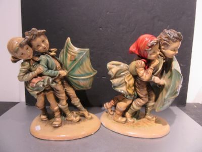 deux figurines d'enfants avec des parapluies posées sur une table