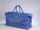 a blue bag sitting on top of a table next to a white wall