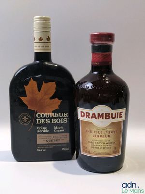 deux bouteilles d'alcool posées l'une à côté de l'autre sur une surface blanche