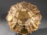 an image of a gold plate with a faceted stone in the center