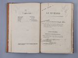 an open book with a handwritten title on it sitting on a blue surface