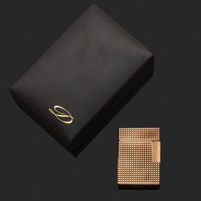 une boîte noire ornée d'un logo doré et d'un bracelet doré