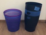 two trash cans sitting next to each other on the floor