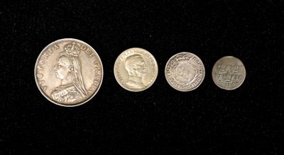 four different types of coins are shown on a black surface