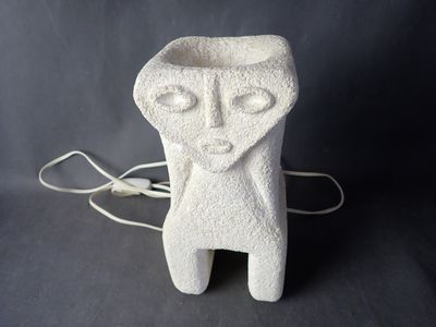 a white ceramic sculpture of a man with a face on it