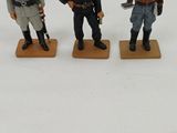 three figurines of men in uniform standing on wooden bases