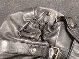 a black purse that is sitting on the ground