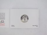 a close up of a piece of silver coin on a white surface