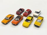 plusieurs petites voitures sont alignées sur une surface blanche
