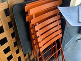 une pile de chaises et une table devant une fenêtre