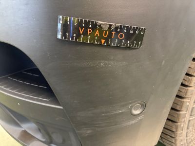 un gros plan du pare-chocs d'une voiture sur lequel est collé un autocollant