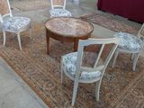 plusieurs chaises et une table dans une pièce dont le sol est recouvert d'un tapis