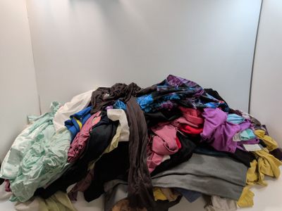 un tas de vêtements posé par terre dans une pièce