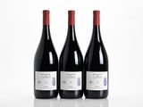 three bottles of red wine sitting next to each other on a table