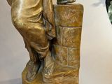 a statue of a woman holding a vase next to a mirror