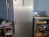 an image of a refrigerator in a room with a lot of clutter on the floor